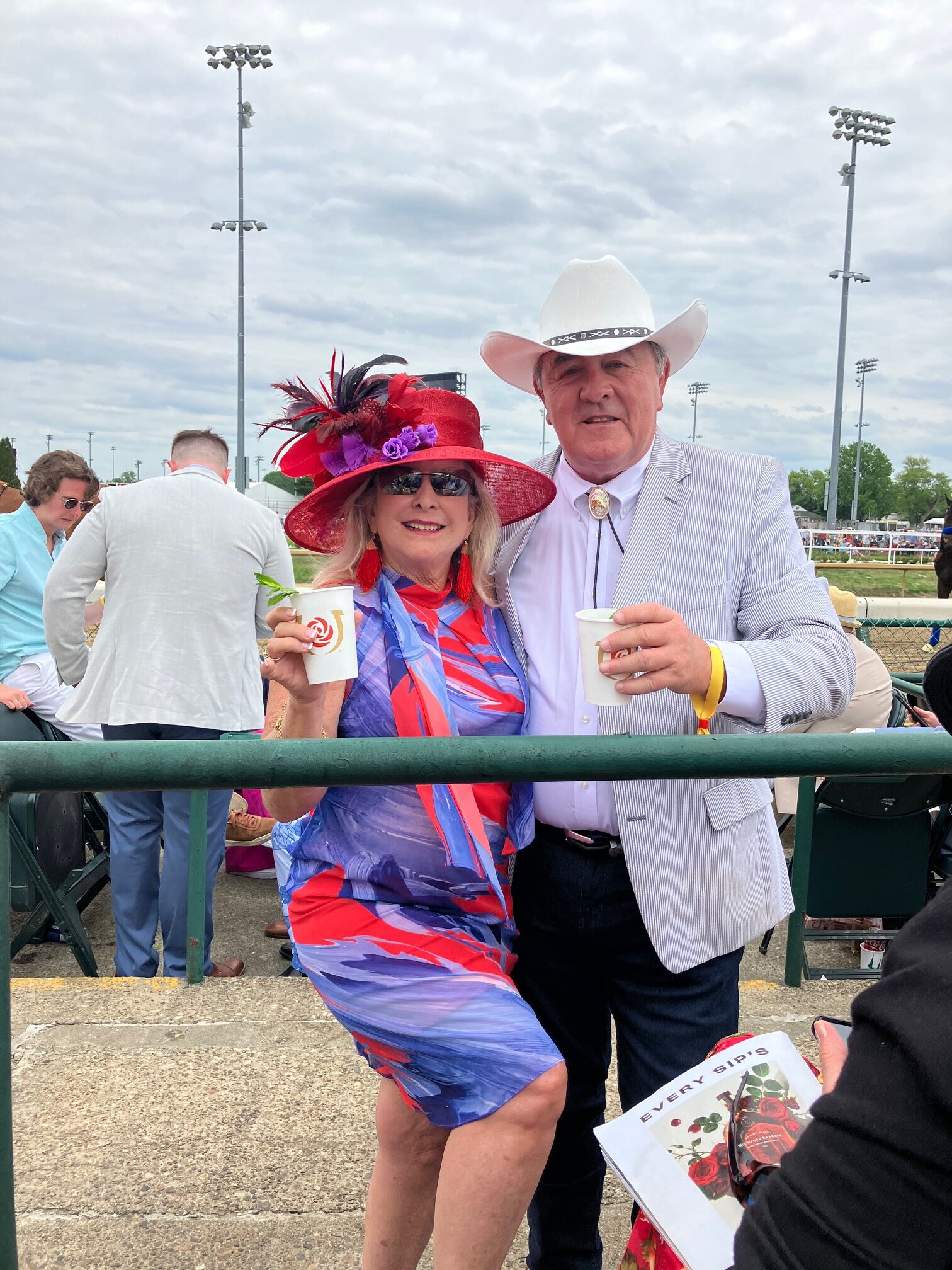 A cheerful couple dressed in vibrant attire at an outdoor event.