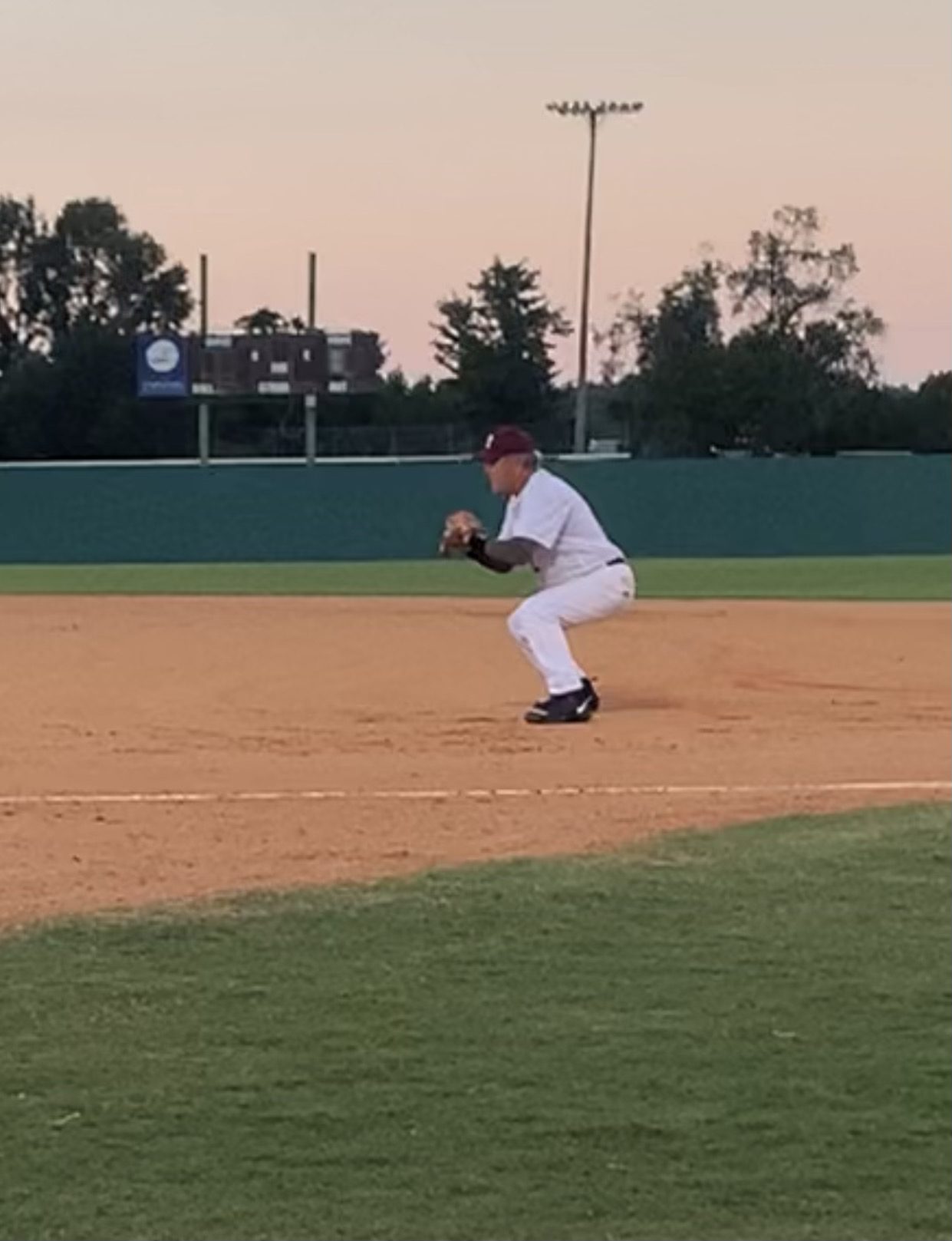 Baseball player ready to field the ball on the infield.